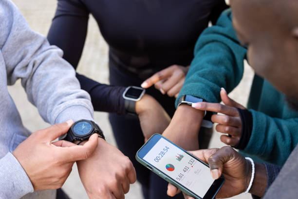 Group of people using smartwatches and a smartphone to track their health and fitness progress.